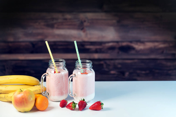 Йогурт в стеклянных банках с фруктами на столе
 - Фото, изображение