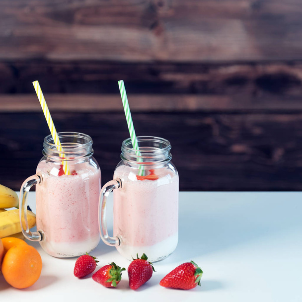 Yogurt in glass jars with fruits on table - Photo, image
