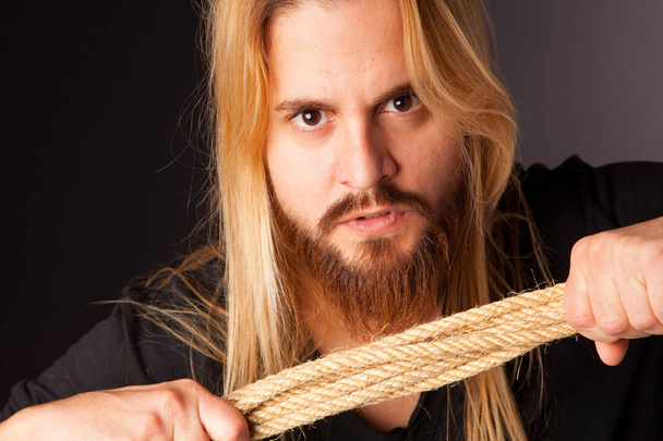 хлопчик з довгим волоссям і бородою з мотузкою на руці
 - Фото, зображення
