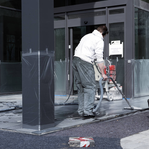 man cleans and polishes marble floor of office building - Photo, Image