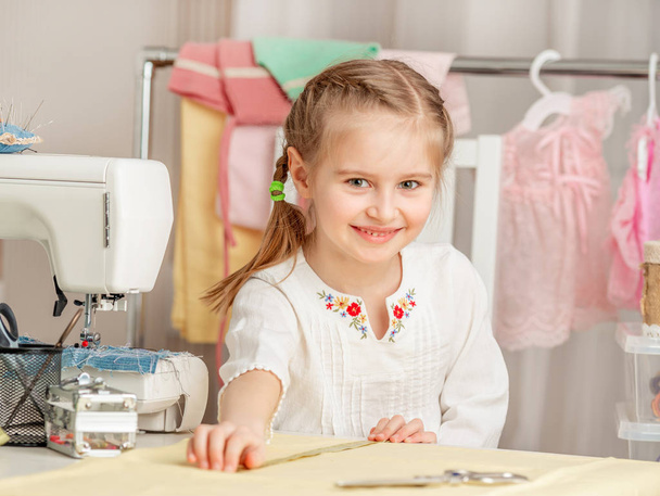 little girl in a sewing workshop - Foto, Bild