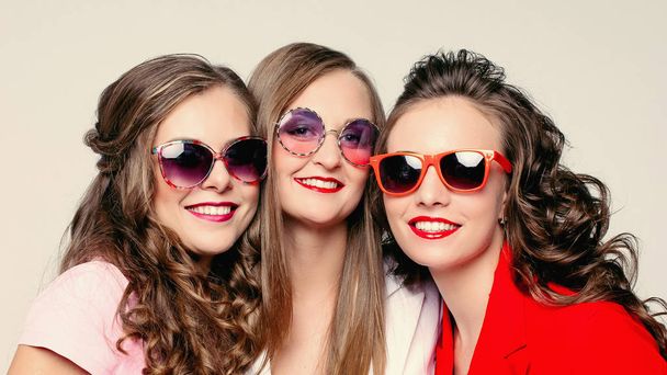 Beautiful happy ladies in fashionable sunglasses and jackets. - Photo, Image