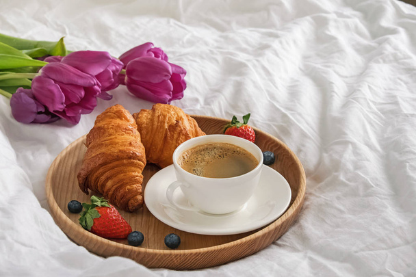 Café, croissants e flores nos lençóis brancos close-up
 - Foto, Imagem