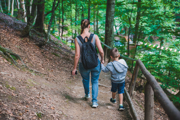 手を繋いでいる林道を歩いての息子を持つ母 - 写真・画像
