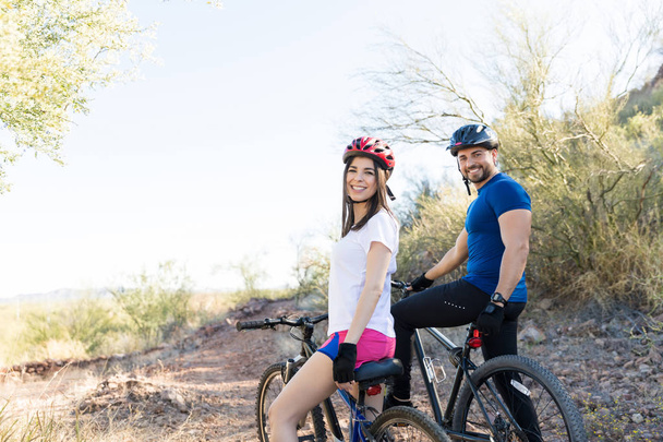 Ritratto di giovane coppia sana che sorride mentre va in bicicletta ad un appuntamento
 - Foto, immagini