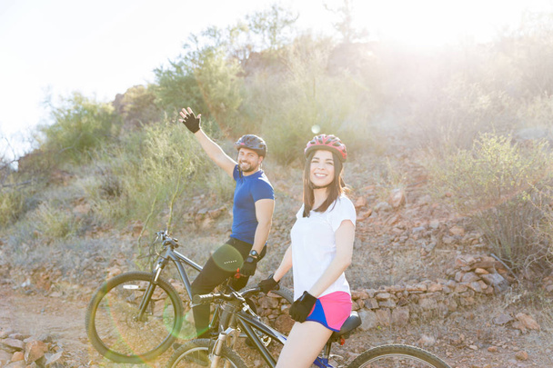 Πορτρέτο του αυτοπεποίθηση ζευγάρι έτοιμο για προπόνηση στο ποδήλατο σε ηλιόλουστη ημέρα - Φωτογραφία, εικόνα