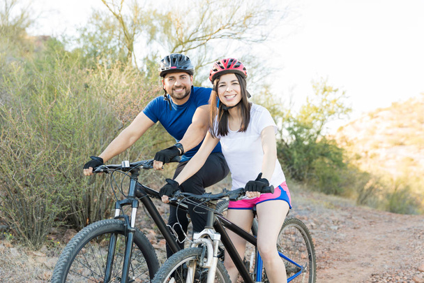 陽気な若い男性と女性サイクリスト自転車に乗って行く自然を探索するには - 写真・画像