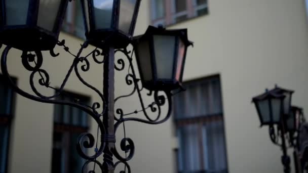 Drievoudige straat lamp in de buurt van historisch gebouw in het centrum van stad. - Video