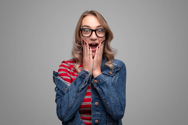 Surprised woman in glasses looking at camera - Foto, afbeelding