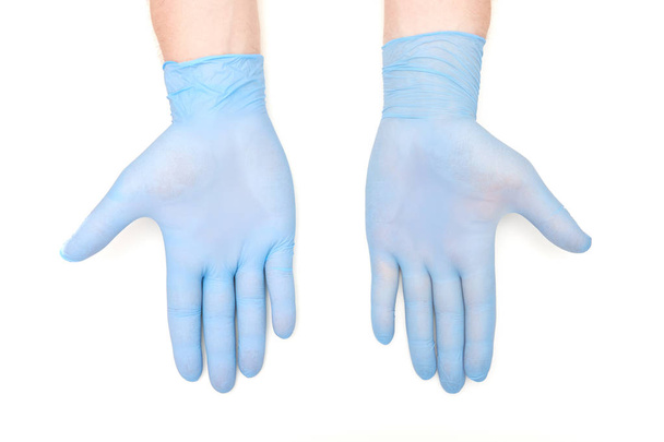 Руки в синих латексных хирургических перчатках с ладонями на белом спинке
 - Фото, изображение