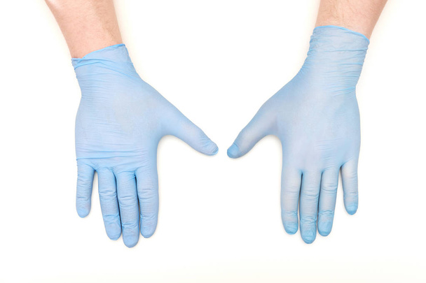 Fehér alapon kék latex sebészeti kesztyűt kezét - Fotó, kép