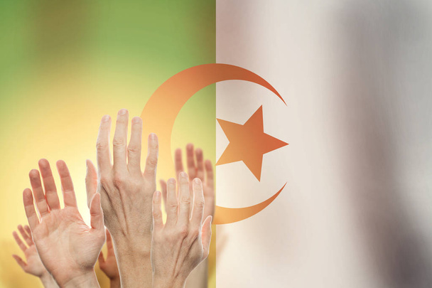 Le persone alzano le mani e l'Algeria bandiera sullo sfondo
.  - Foto, immagini