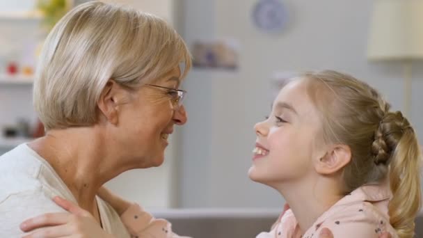 Granny and granddaughter nuzzling, playing games, having fun together, closeup - Materiał filmowy, wideo