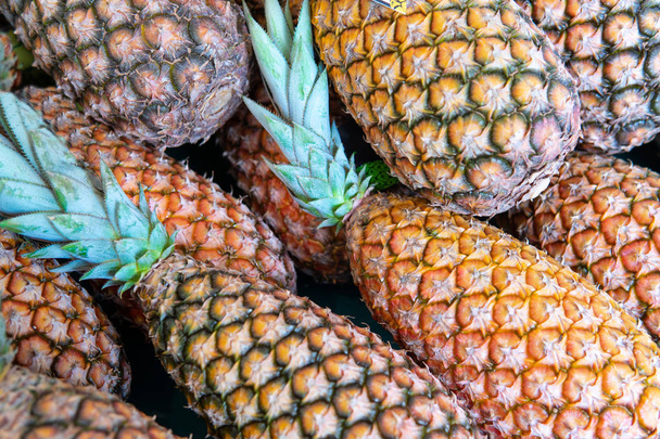 Grupo de piñas frescas fruta tropical en el gourmet o market.Organic ananas están maduras con ramas de palma. Verduras y frutas en el mercado de bandejas granja agrícola
. - Foto, imagen
