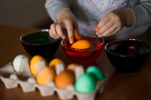 Frohe Ostern. kleines Malmädchen bemalte Eier. Kind bereitet sich auf Ostern vor. bemalte Hand. Kunst- und Bastelkonzept. traditionelles Frühlingsessen - Foto, Bild