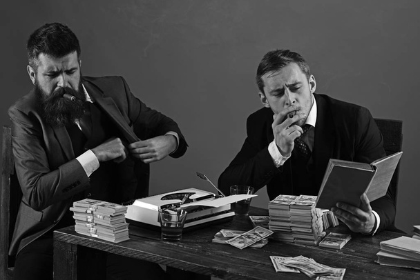 Necessary information. Successful investment in business. Businessmen write financial report while drinking and smoking. Business partners with cash money. Money brokers counting profit increase - 写真・画像