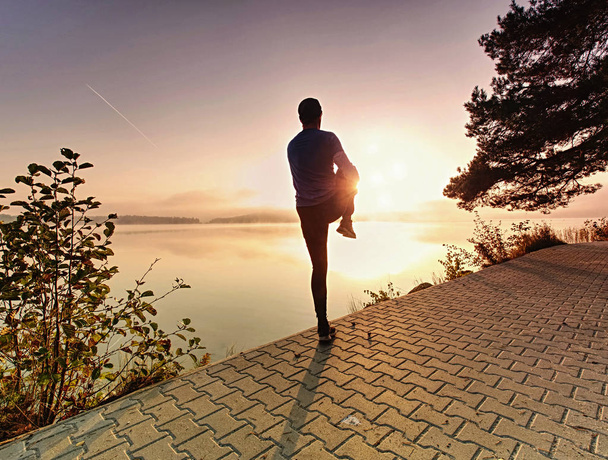Esporte ativo homem corredor alongamento corpo no lado do lago pavimento
, - Foto, Imagem