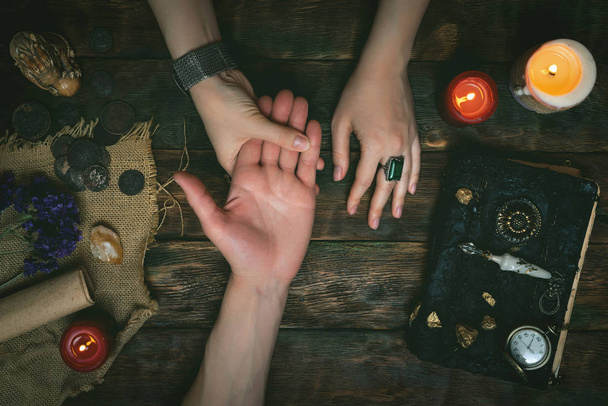 Palmistry concept. Fortune teller reading future on the hand on a magic table background. Future reading concept. - Φωτογραφία, εικόνα
