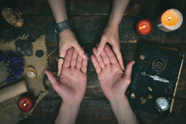 Palmistry concept. Fortune teller reading future on the hand on a magic table background. Future reading concept. - Photo, Image