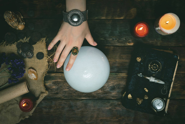 Future teller and a crystal ball is reading a future on a magic table background. - 写真・画像