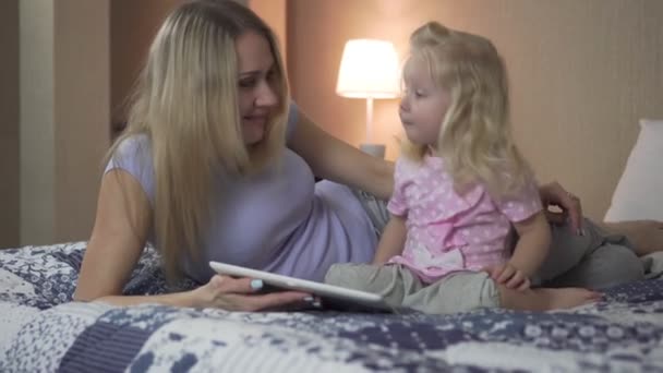 Ευτυχισμένη οικογένεια, γυναίκα και παιδί χρησιμοποιώντας υπολογιστή tablet στο σπίτι στο κρεβάτι. - Πλάνα, βίντεο