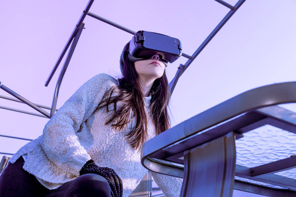 Vr achtergrond roze paars blauw meisje gezicht vrouw Virtual Reality headset brunette telefoon futuristische Violet Sky Furniture - Foto, afbeelding