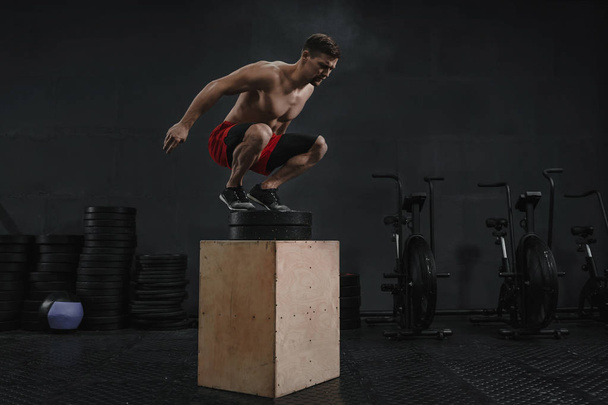 Crossfit κουτί άλμα άσκηση. Αθλητής που πηδά επάνω στο κιβώτιο - Φωτογραφία, εικόνα