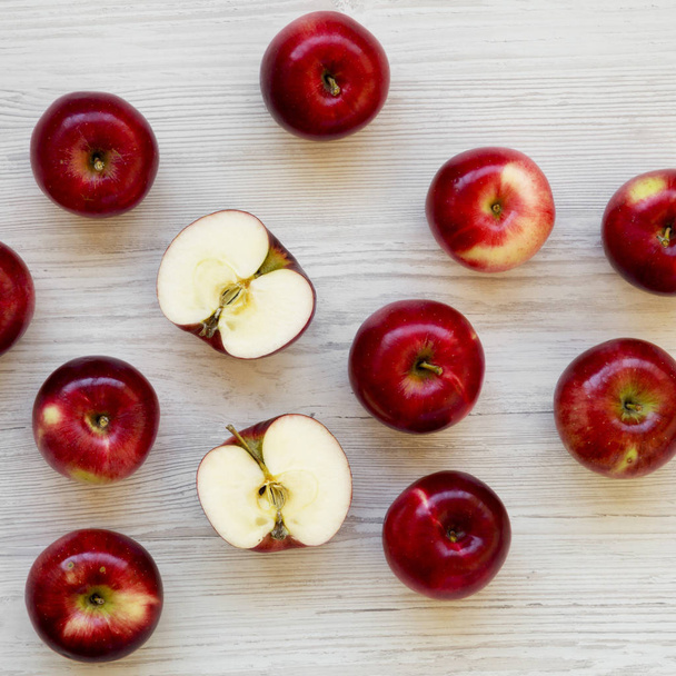 RAW κόκκινα μήλα σε λευκή ξύλινη επιφάνεια, υπερκείμενη προβολή. Επίπεδη θέσει, - Φωτογραφία, εικόνα