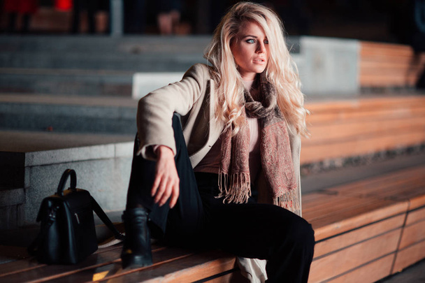 Pensive blonde sitting on bench. - Fotoğraf, Görsel