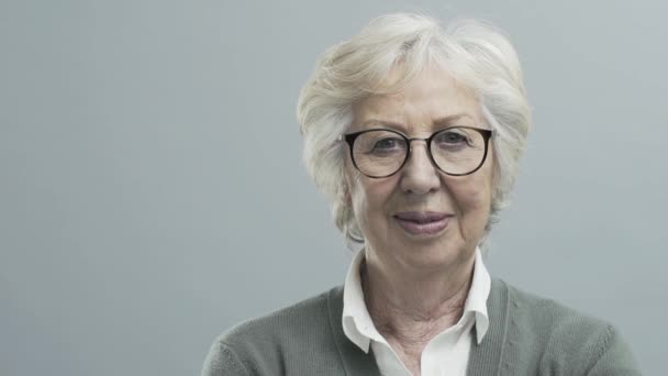Smiling confident senior lady with glasses - Video, Çekim