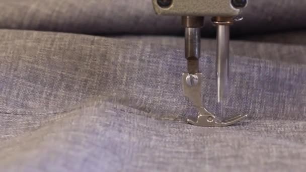 Process of furniture production. Closeup of An older woman in a dark coat is sewing the material for the sofa with a sewing machine. - Footage, Video