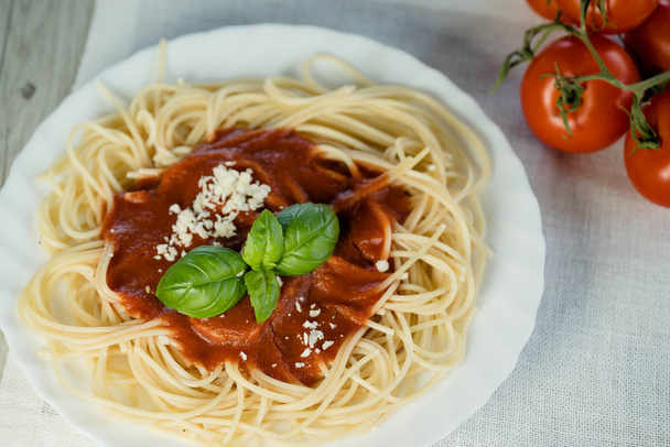 Pastas italianas con salsa de tomate y hojas de albahaca
 - Foto, imagen