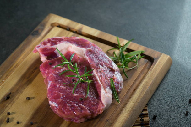 Close up of raw steak meat on chalkboard with spices - Zdjęcie, obraz