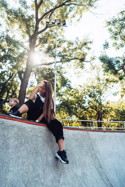 Beautiful young hipster girl sitting on the edge of a ramp - Fotografie, Obrázek