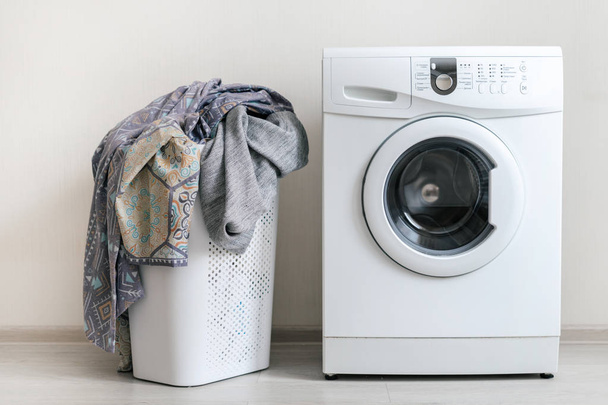 Lavanderia interior com máquina de lavar roupa perto da parede
 - Foto, Imagem