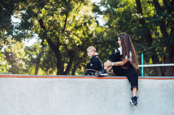 Belle jeune maman hipster et petit fils au skatepark - Photo, image