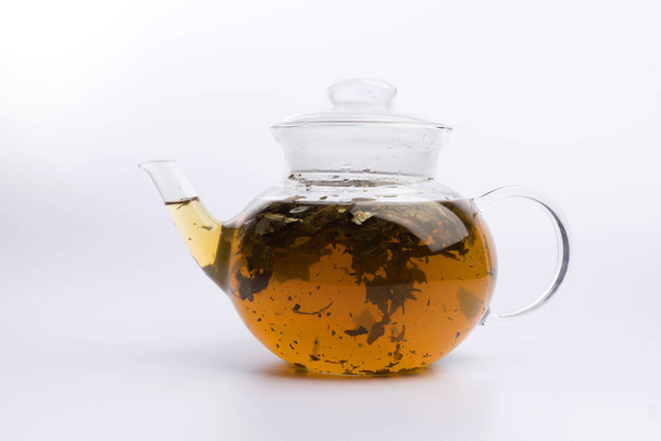 Teapot with green bilolgical tea isolated on white background - Foto, immagini