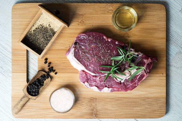 Закрыть сырое мясо стейка на доске со специями
 - Фото, изображение