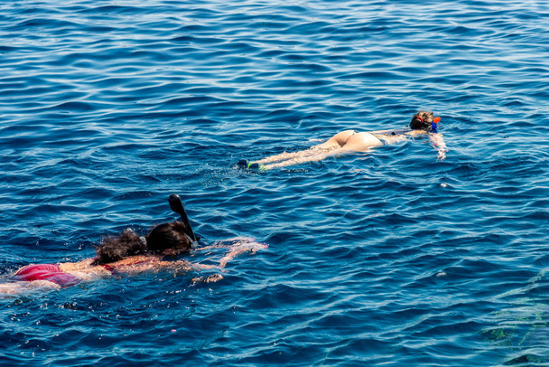 Reizen en vrije tijd, twee meisje in een masker met een buis snorkelen - Foto, afbeelding