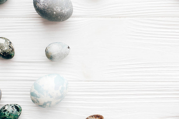 Elegantes huevos de Pascua plana ponen sobre fondo de madera blanca con spa
 - Foto, imagen