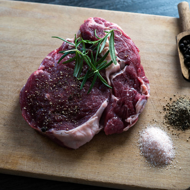 Bliska stek surowego mięsa na tablicy z przyprawami - Zdjęcie, obraz