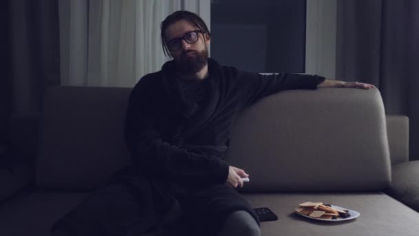 Handsome bearded man watching tv - Кадри, відео