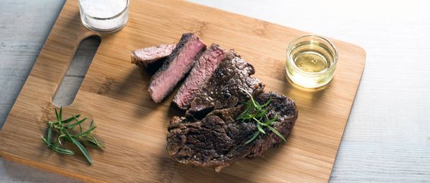 Otlar ile kara tahta üzerinde biftek dilimlenmiş apetisant - Fotoğraf, Görsel