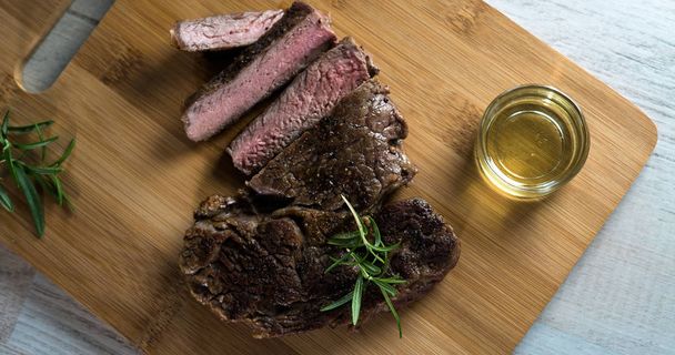 Otlar ile kara tahta üzerinde biftek dilimlenmiş apetisant - Fotoğraf, Görsel