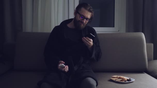 Handsome bearded man watching tv - Felvétel, videó
