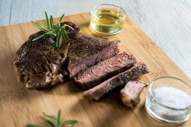 Appetitlich geschnittenes Steak auf Kreide mit Kräutern - Foto, Bild