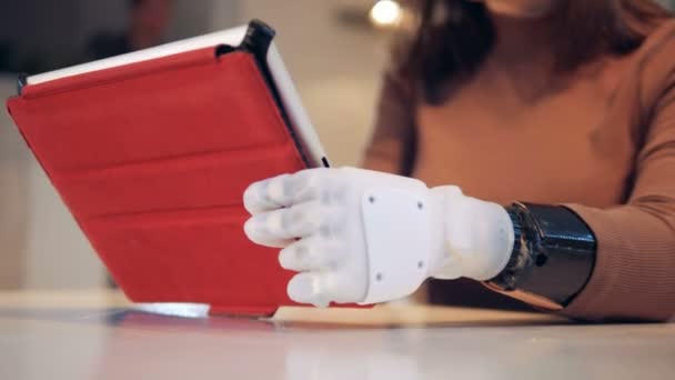 Woman with prosthetic hand uses a tablet, close up. - Felvétel, videó