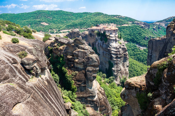 Top view of Monastery of Varlaam (the second largest) in Meteora, Greece, and the unique rock formations around it, above Kalabaka town, on a bright sunny day during the Summer season. - Foto, Bild