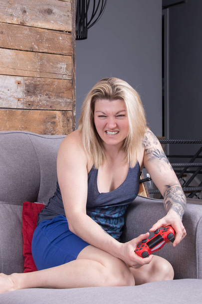 blond woman playing video games expression concentration - Photo, Image