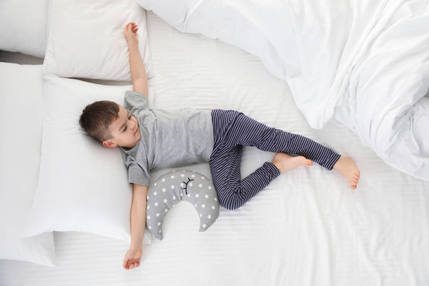 Cute little boy with toy sleeping on bed, above view - Photo, Image